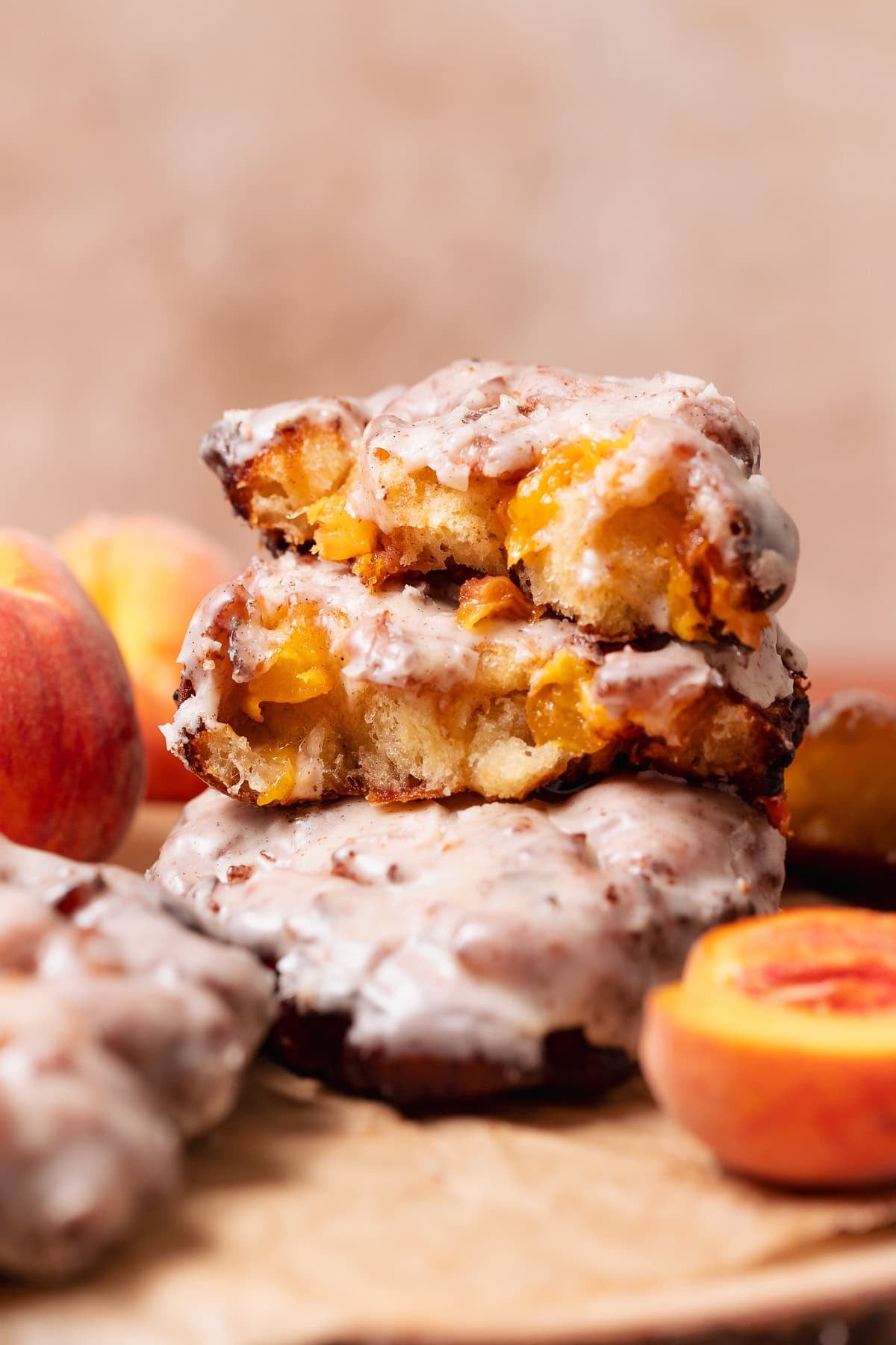 Stacked peach fritters filled with fresh peaches and coated in brown butter glaze.