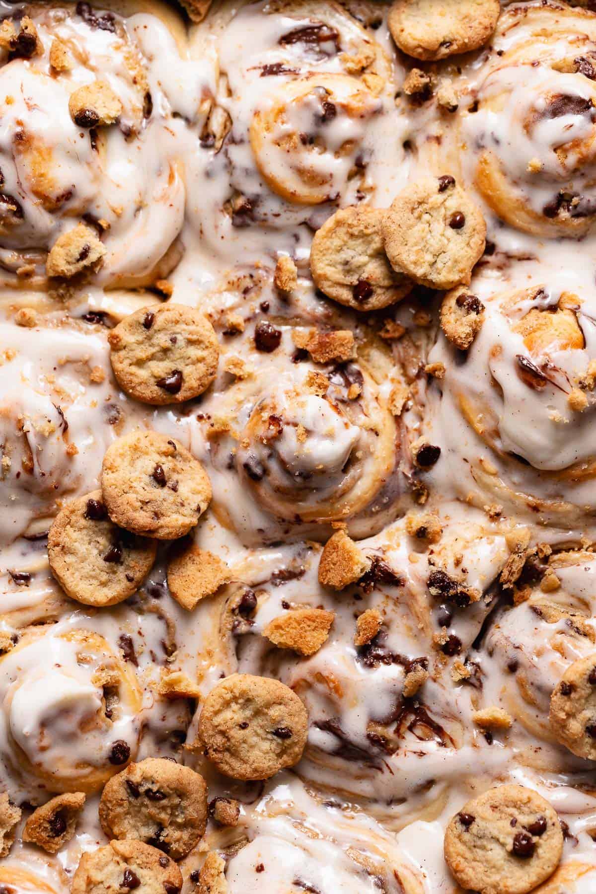 Chocolate chip rolls with vanilla icing and mini cookies on top.