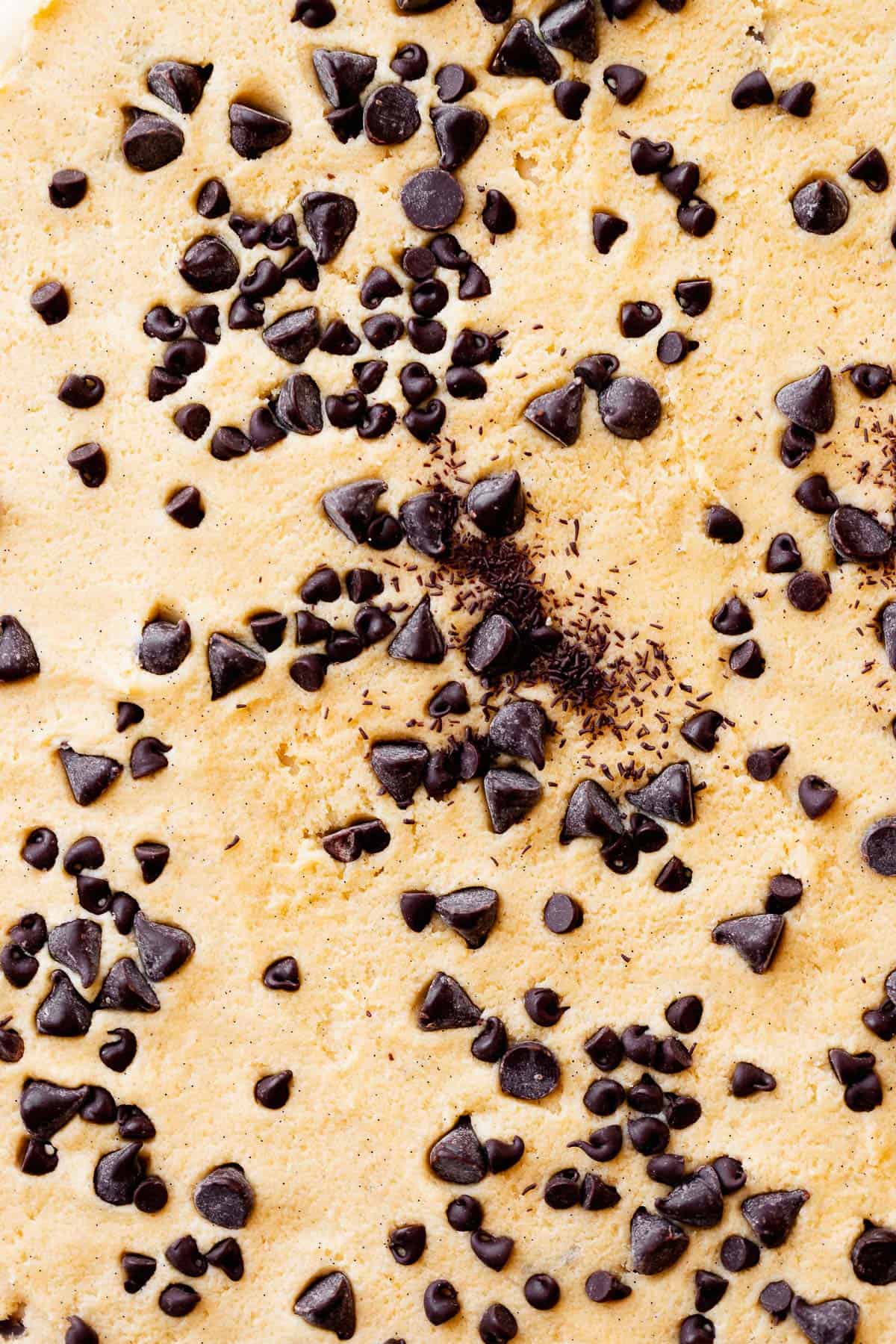 Chocolate chip cookie dough filling spread over cinnamon roll dough before rolling.