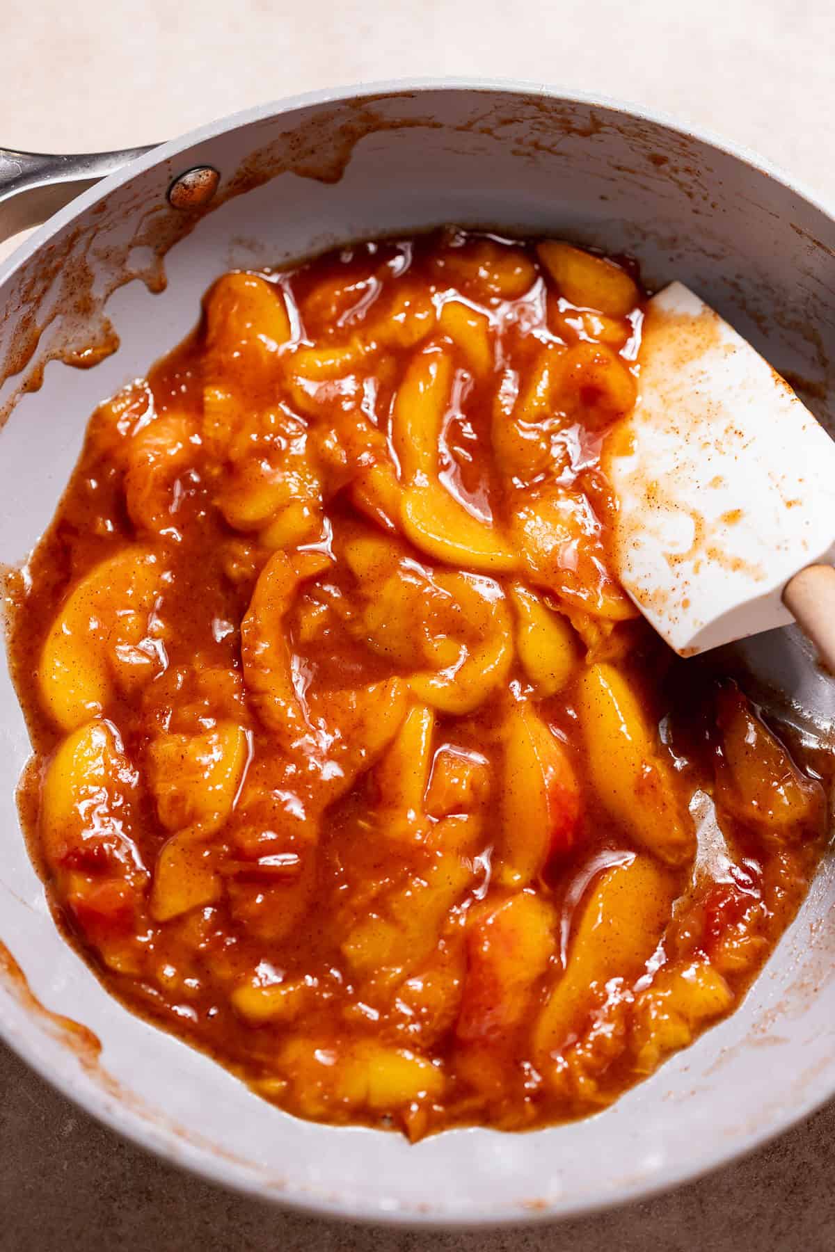 Cinnamon brown sugar peach filling cooking in a skillet.