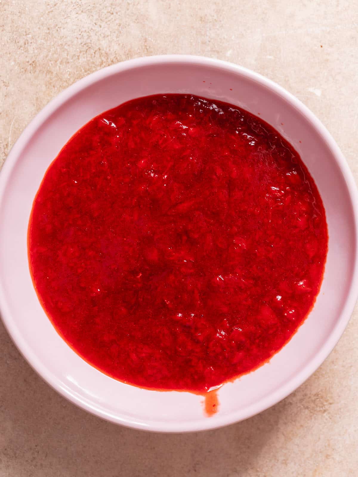Homemade strawberry jam filling in a bowl for strawberry cheesecake bars.