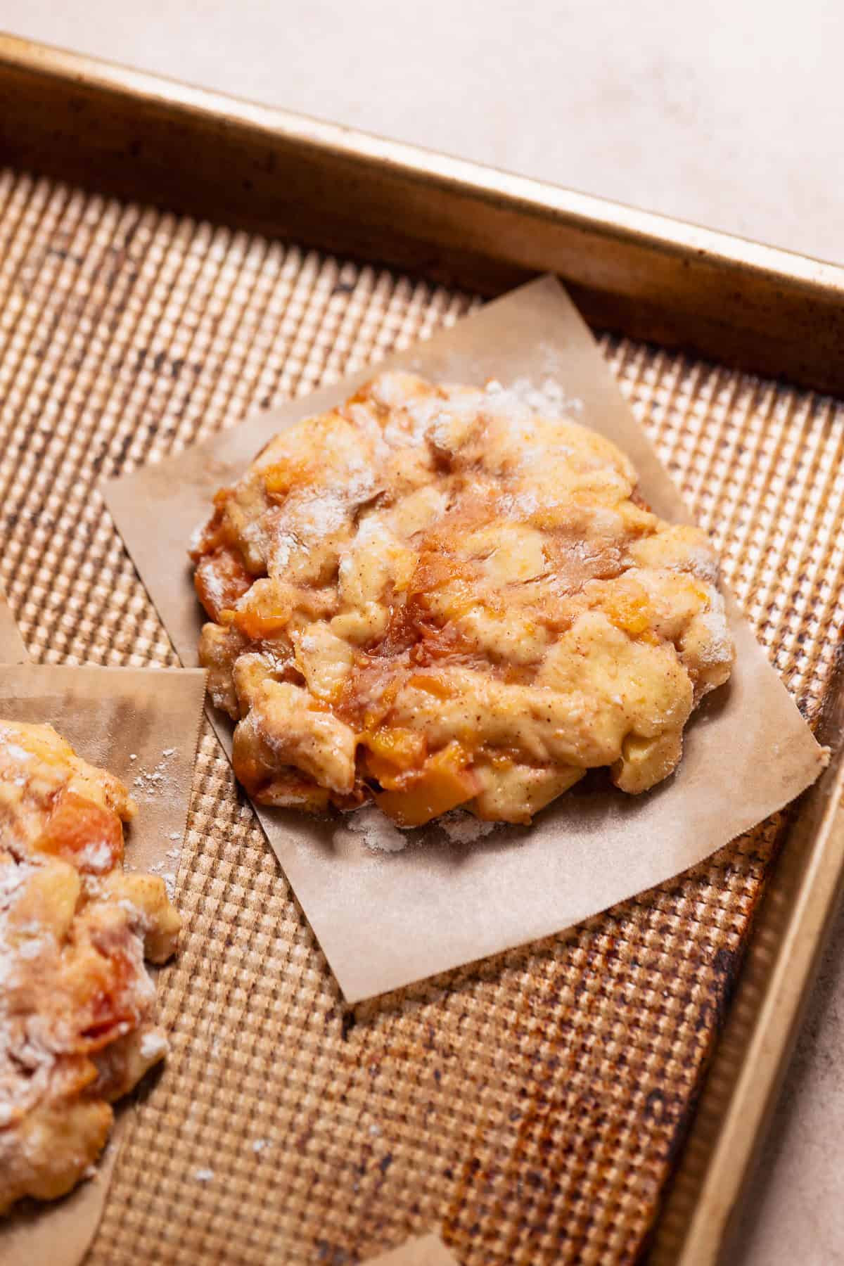 Raw peach fritters on a sheet pan before frying.