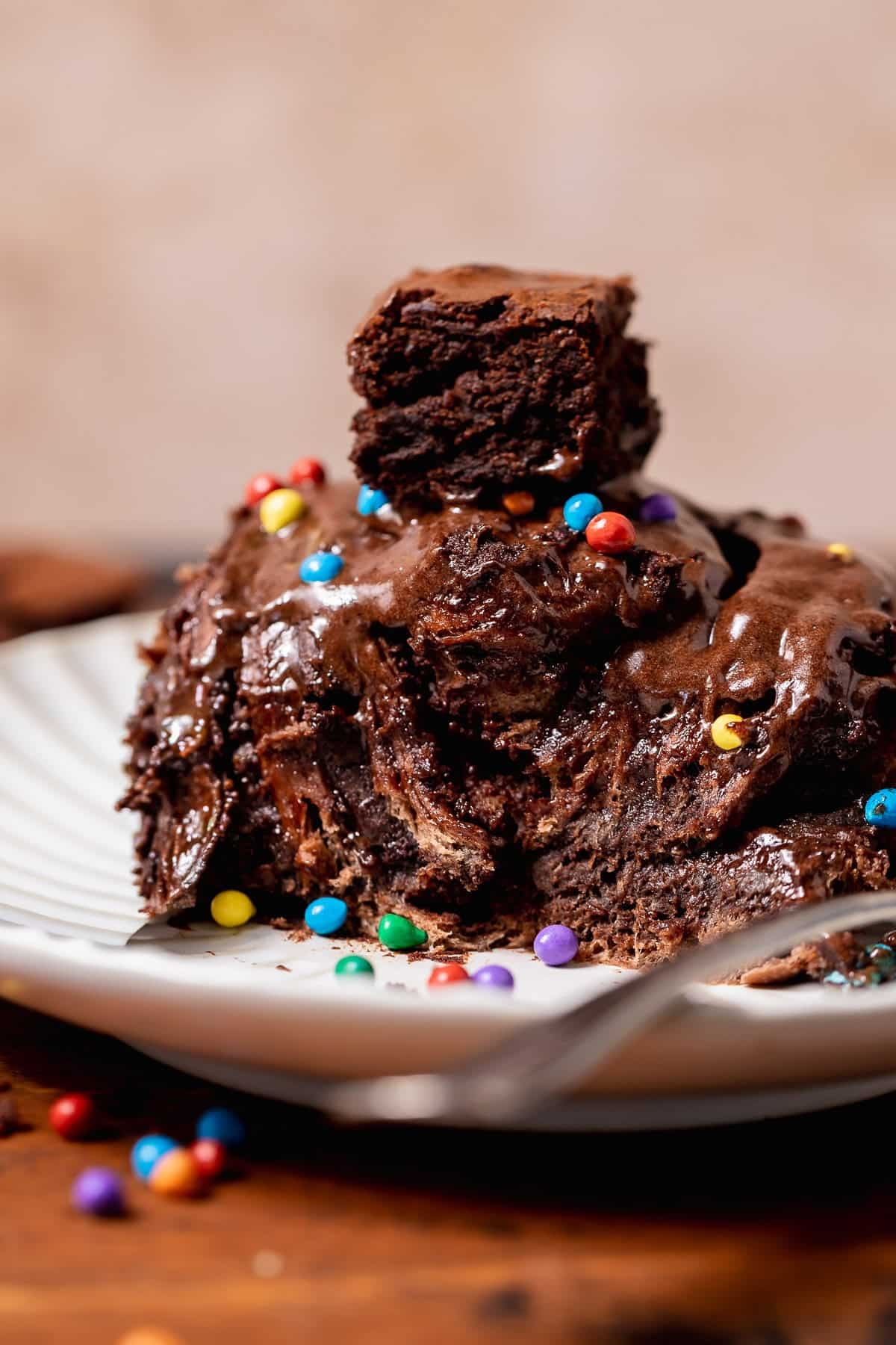 Cosmic brownie roll pulled apart on a plate, revealing gooey chocolate layers, brownie filling, and chocolate frosting inside.