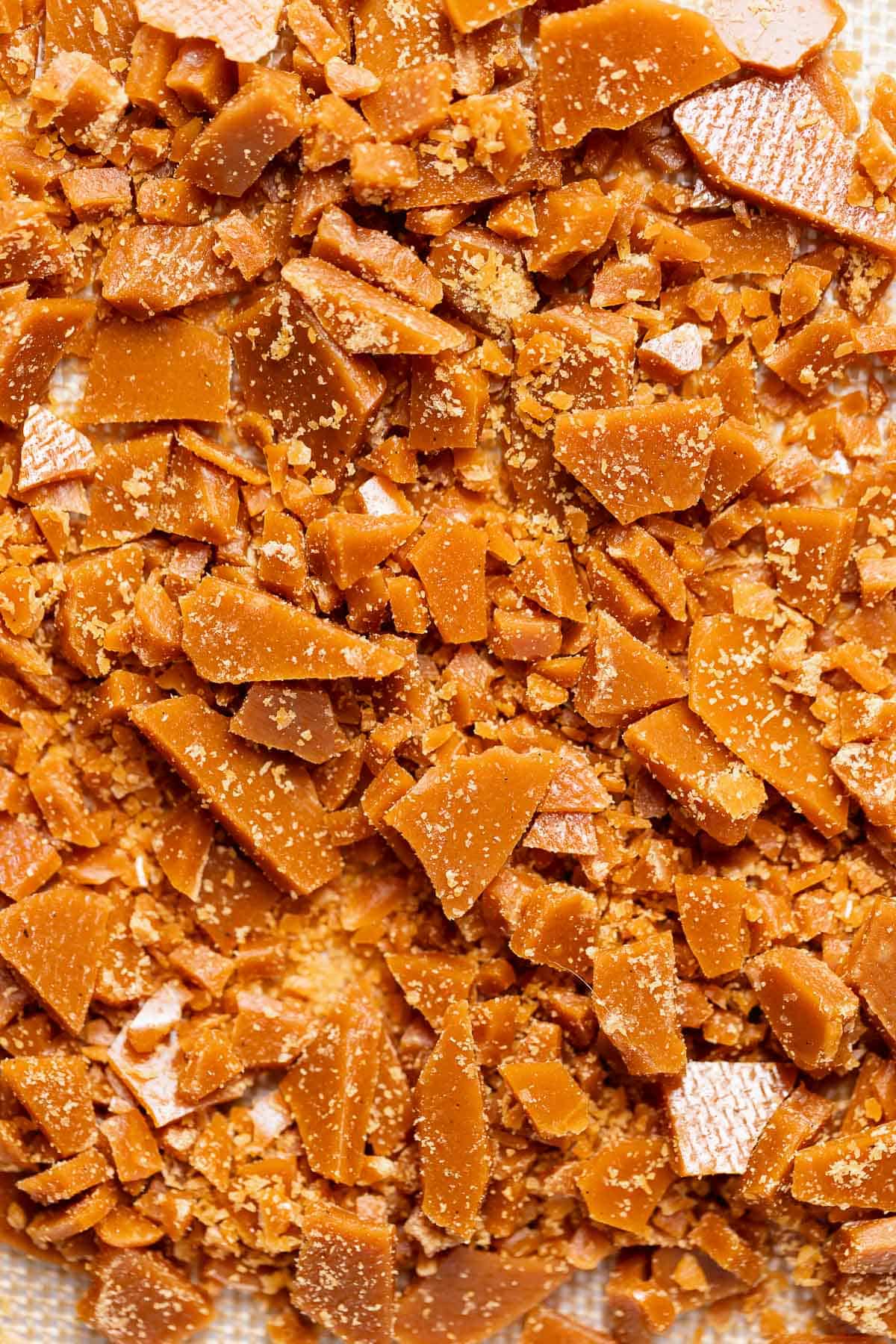 Close-up of homemade buttery toffee broken into crunchy pieces for the cookie dough.