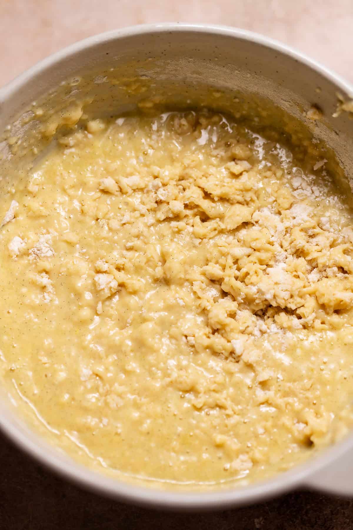 Dry ingredients partially mixed into the wet ingredients for homemade muffin batter.