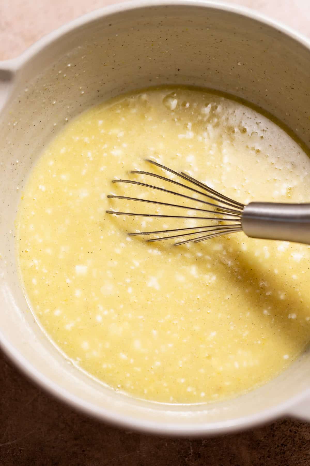 Wet ingredients whisked together for the muffin batter in a mixing bowl.