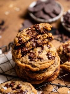 Stack of oatmeal chocolate chip cookies with a broken cookie showing a gooey chocolate center.