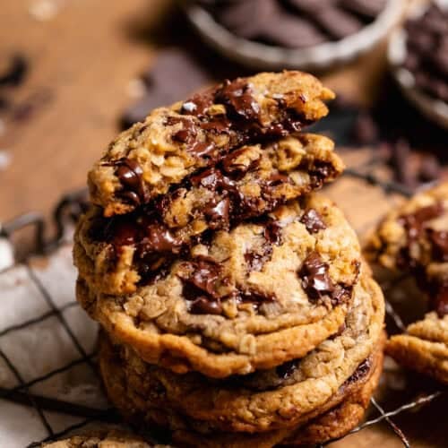 Stack of oatmeal chocolate chip cookies with a broken cookie showing a gooey chocolate center.