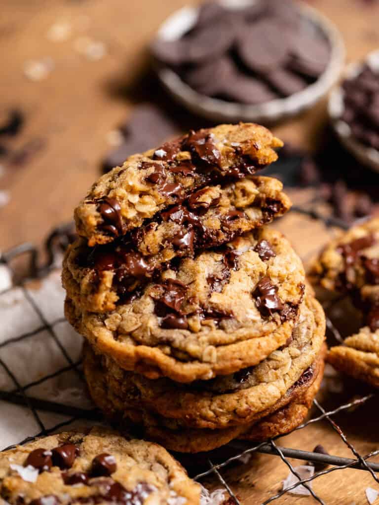 Stack of oatmeal chocolate chip cookies with a broken cookie showing a gooey chocolate center.
