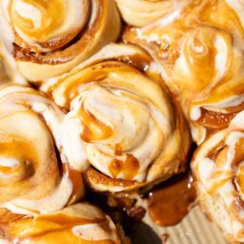 Caramel cinnamon rolls topped with caramel cream cheese frosting swirled with salted caramel sauce.