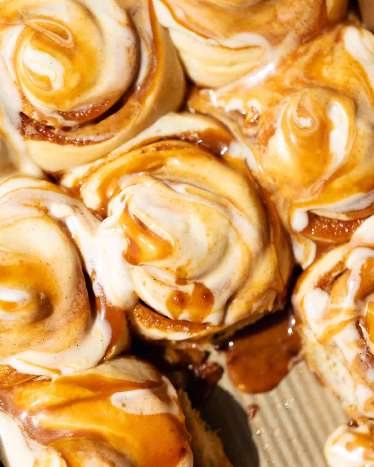 Caramel cinnamon rolls topped with caramel cream cheese frosting swirled with salted caramel sauce.