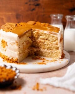 Biscoff layer cake with a large slice removed to show three cake layers and cookie butter frosting inside.