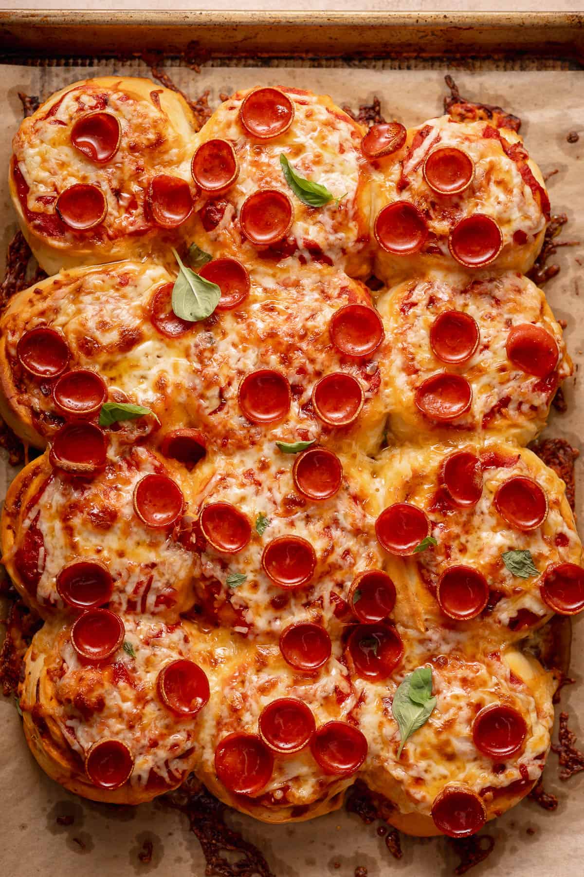Fully baked pepperoni pull apart rolls with browned melted cheese and mini cup pepperoni on top.
