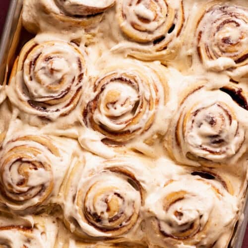 A baking pan filled with frosted cinnamon rolls.